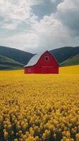 A red barn surrounded by vibrant yellow flowers in a scenic rural landscape with mountains photo