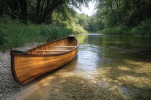 A peaceful canoe rests by the clear waters of a calm river at sunset photo