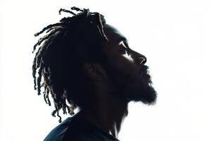 Profile of a man with dreadlocks against a bright background showcasing his thoughtful expression photo