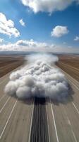 Dust clouds rise over an airport runway at sunset with planes parked nearby photo