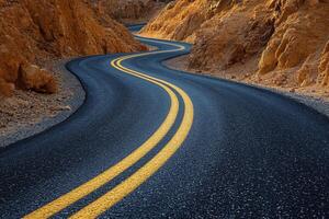 Curving mountain road winding through rocky terrain under cloudy sky during early morning photo