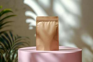 A gold packaging pouch displayed on a pink pedestal surrounded by green foliage in natural light photo