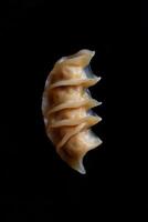 Crispy dumplings stacked neatly on a black background, showcasing golden brown texture and details photo