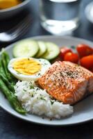 Delicious salmon dish with rice, vegetables, and a perfectly cooked egg served on a gray plate photo