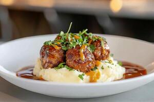 Delicious meatballs on a bed of creamy mashed potatoes served in a cozy dining setting photo