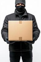 Delivery person in black attire holds a cardboard box against a plain background photo
