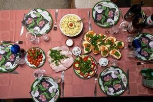Festive table setting featuring salmon canaps, ham, salad, and cherry tomatoes photo