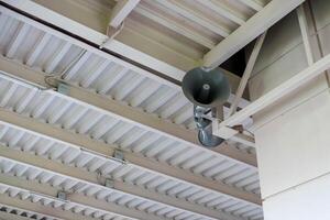 Public address system hanging from metal ceiling structure photo