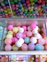 Colorful and vibrant display of bead balls fills a glass case in a store. Accessories things. Do it yourself creativity. photo