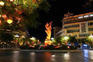 DUNHUANG, CHINA - OCT 20, 2024- Night view of flying Apsara statue in the center city of Dunhuang, Gansu, China photo