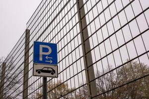 Parking sign indicating available parking spaces behind metal fence photo