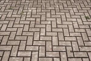 Herringbone pattern brick paving forming textured ground surface photo