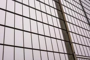 Metal mesh wire fence creating repeating pattern against cloudy sky photo