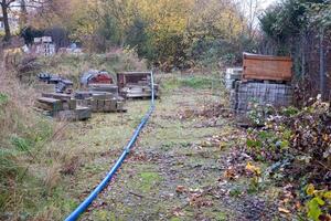 Building materials lying on ground at construction site with blue pipe photo