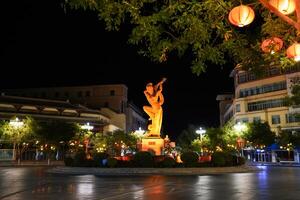 DUNHUANG, CHINA - OCT 20, 2024- Night view of flying Apsara statue in the center city of Dunhuang, Gansu, China photo