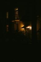 Soft glow from a porch light illuminates a dark evening in a quiet neighborhood photo