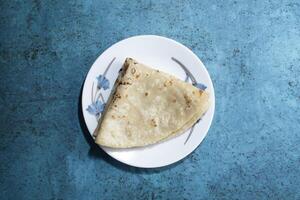 Plain roti or chapatti served in plate isolated on grey background top view of bangladeshi food photo