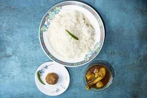 Plain Rice with Chicken curry korma and alu bhorta served in plate isolated on grey background top view of bangladeshi food photo