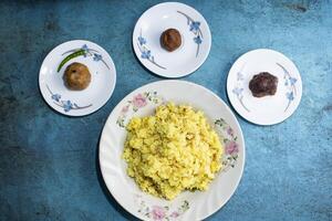Yellow Moong Dal Khichdi with Alu bhorta served in plate isolated on grey background top view of bangladeshi food photo