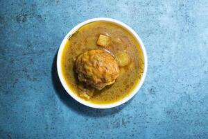 Egg curry with potato served in bowl isolated on sky background top view of bangladeshi food photo
