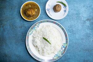 Plain Rice with egg curry and alu bhorta served in plate isolated on grey background top view of bangladeshi food photo