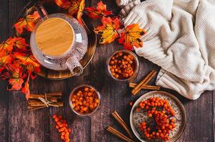 Tea with rowan berries in glasses and a teapot on the table top view photo
