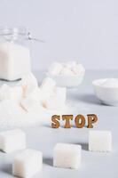 Concept of limited sugar consumption, text and sugar on the table vertical view photo