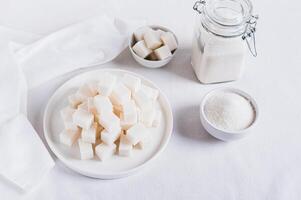 Alternative choice between lump sugar and granulated sugar on white background photo