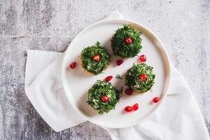 Close up of tuna, egg and dill salad shaped like Christmas trees on crackers on a plate top view photo