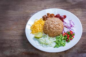 Shrimp paste fried rice or Khao kluk kapi is a delicious Thai dish that combines many ingredients such as shrimp paste, mixed with Thai jasmine rice and various side dishes. photo