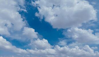 Sky background image. Bottom up view of beautiful blue sky and white clouds at noon in summer. photo