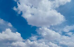 Sky background image. Bottom up view of beautiful blue sky and white clouds at noon in summer. photo