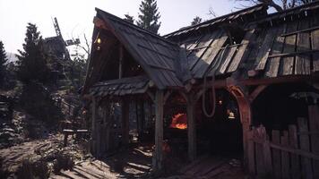 Abandoned rustic cottage in a forest with a glowing forge at dusk photo