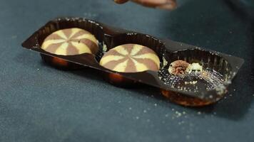 Someone took three biscuits in a plastic packing container. A snack made from sweet chocolate flavored flour video