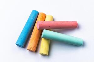 Crayons of different colors arranged on a white background. Education photo