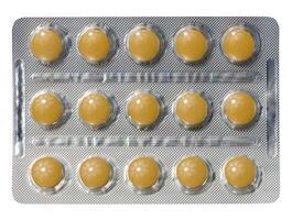 Blister pack with round yellow pills on isolated background photo