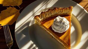 Pumpkin pie slice with whipped cream and autumn leaves video