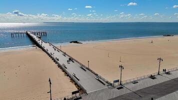 Aerial view Pat Auletta Steeplechase Pier and Boardwalk in Brooklyn, Steeplechase Pier extending into the ocean, with a sandy beach and boardwalk in Brooklyn. video