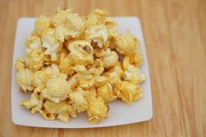 Homemade popcorn, made from seeds of maize or corn by baking or heating, mixed with salt, sugar and butter caramel. Concept, delicious snack. Agriculture product as food. photo