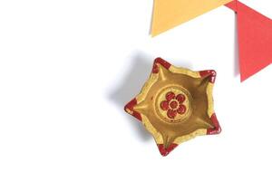 Colorful golden star shape festival diya with colored paper flags on white background photo