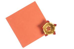 Decorative orange square paper with golden star shaped diya for festive celebrations photo