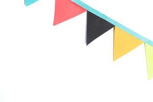 Colorful paper bunting flags on white background with copy space. Perfect for parties and celebrations photo