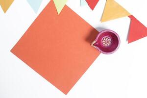 Vibrant orange paper note with diya and decorative flag for Diwali celebration photo