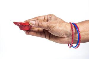 Hand of old woman holding red oil lamp isolated on white background photo