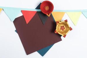Golden Diya with Blank Card and Colorful Flags for Diwali Message on White Background photo