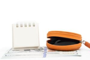 Open Orange Coin Pocket and Blank Calendar isolated on white background with copy space. Financial crisis, poverty, lack of money concept. Open empty coin wallet. photo