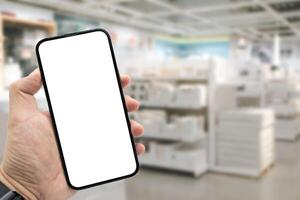 Mockup blank screen mobile phone for app or web site mockup. Smart phone with white screen in hand on Blur furniture store background. photo