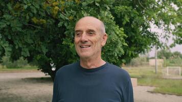 Bald Happy Senior Man Smiles To Waist Looking At Himself In Nature Park video