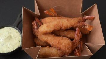Hot crispy shrimp breaded with salt and spices with white sauce on a dark concrete background video
