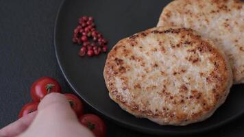 Grilled chicken burger cutlet with salt, spices and herbs on a dark concrete background video